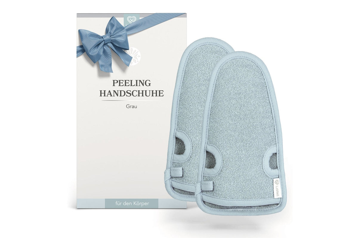 Zwei graue Peelinghandschuhe vor der Geschenkverpackung mit Schleife