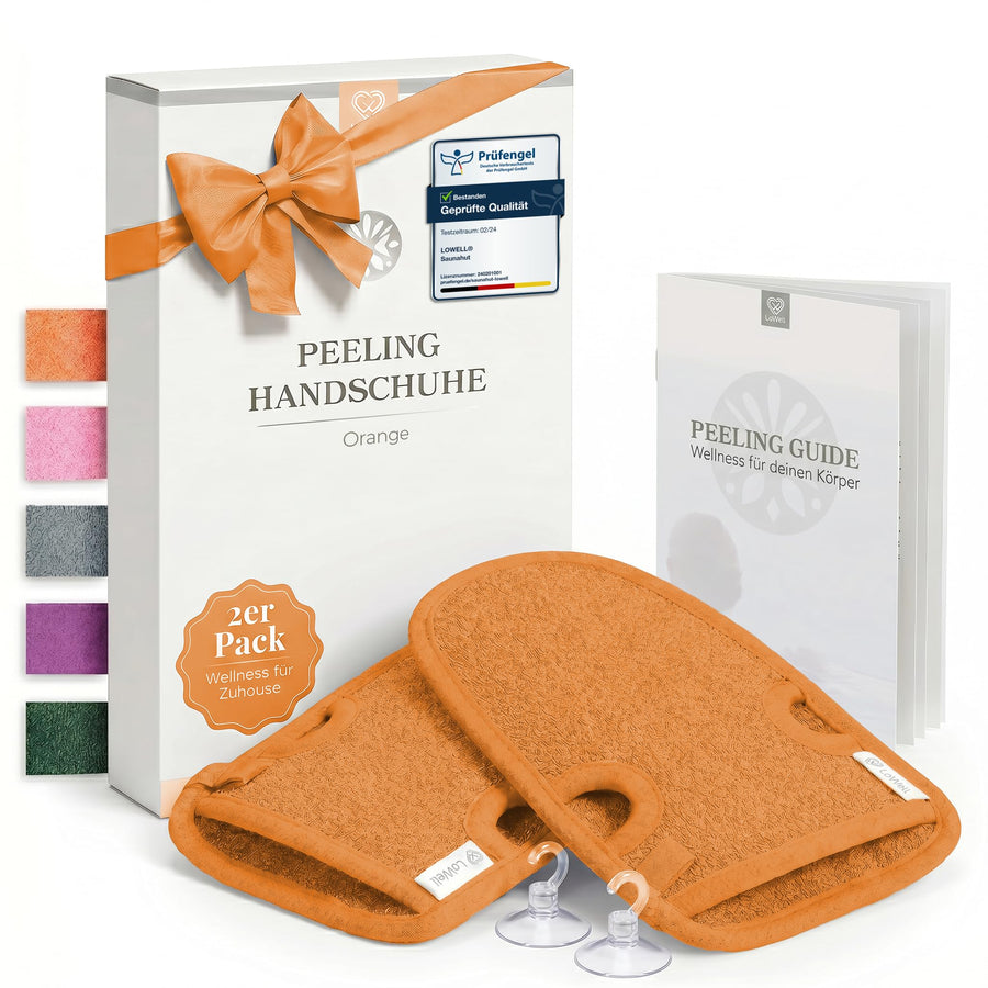 Zwei Peeling-Handschuhe in Orange vor Geschenkbox mit oranger Schleife, dazu zwei Saughaken